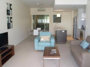 - un salon avec un canapé et une table dans l'établissement Itara Apartments, à Townsville