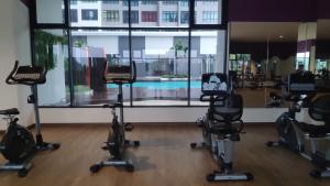 a gym with exercise bikes and a swimming pool at Conezion Luxury 3BR for 7pax @IOI Resort Putrajaya in Putrajaya