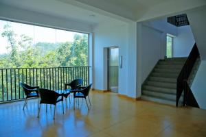 a dining room with a table and chairs on a balcony at Glenloch Tea Factory Hotel in Ramboda