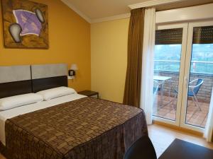 a hotel room with a bed and a balcony at Hotel Reigosa in Pontevedra