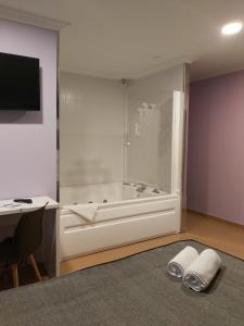 y baño con bañera, escritorio y escritorio. en Hotel Reigosa, en Pontevedra