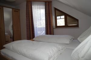 a bedroom with two white beds and a window at Appartementhaus Sabine in Kötschach