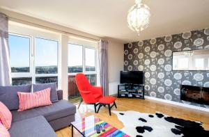 - un salon avec un canapé et un fauteuil rouge dans l'établissement Ultra Urban Belfast Apartments, à Belfast