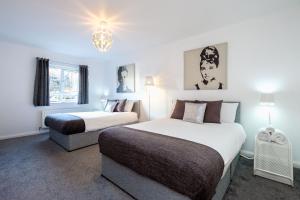 une chambre avec deux lits et un lustre dans l'établissement Ultra Urban Belfast Apartments, à Belfast