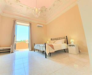 a bedroom with a bed and a large window at Antica Dimora Barocca in Acireale