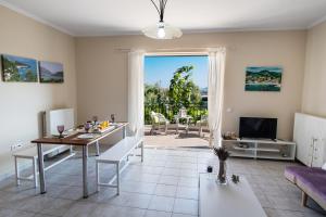 a living room with a dining table and a view of a patio at Kalianna apartments in Lefkada