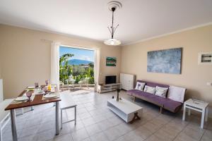 a living room with a purple couch and a table at Kalianna apartments in Lefkada