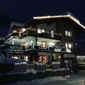 ヒパッハにあるApart Edelweissの雪中のクリスマス灯付きの家