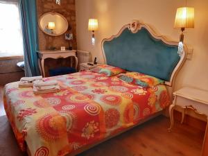 a bedroom with a large bed with a colorful comforter at Quinta Sao Miguel de Arcos in Vila do Conde +37 photos