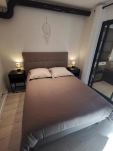 a large bed in a room with two night stands at 2 pièces Vieux-Nice S in Nice