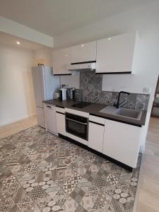 een keuken met witte kasten en een tegelvloer bij Appartement Vieux Nice S in Nice