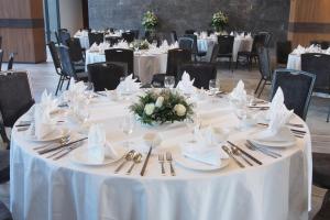 a round table with white tablecloths and silverware at The Teak Hotel in Mae Sot +82 photos