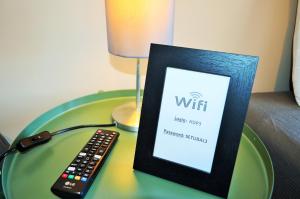 a remote control sitting next to a picture on a table at Suites & Apartments - DP Setubal in Setúbal