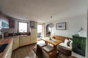 a kitchen with a table and a couch in a room at Appartement Wilder Kaiser in Kitzbühel +6 photos