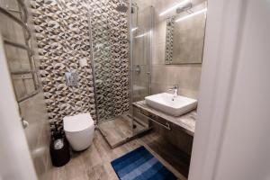 a bathroom with a sink and a toilet and a shower at Університетська вулиця Апартам in Uzhhorod