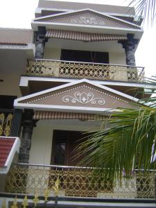 a building with a balcony and a plant in front of it at Prems Homestay in Cochin