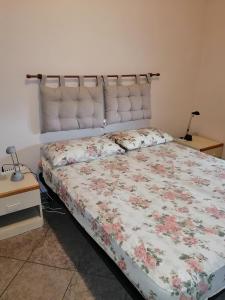- une chambre avec un lit et une couette à fleurs dans l'établissement Liguria di Ponente Albenga collina, à Albenga