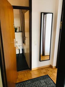 a door leading into a bathroom with a mirror at Messe Apartment Köln West in Cologne