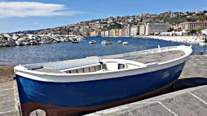 una barca blu e bianca seduta su un molo di NAPOLIXSUITE a Napoli