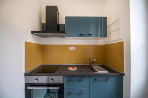 a small kitchen with blue cabinets and a sink at Qu4ttro I Salerno 1950 in Salerno