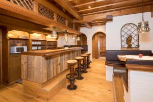 una cocina con una barra con una fila de taburetes en Angerer Alpine Suiten und Familienappartements Tirol, en Reith im Alpbachtal