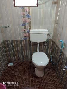 a bathroom with a toilet in a shower at VANASIRI COTTAGE (Tourist Home) in Dharmastala