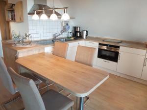 eine Küche mit einem Holztisch und Stühlen in der Unterkunft Ferienwohnung Dienst in Hagenburg