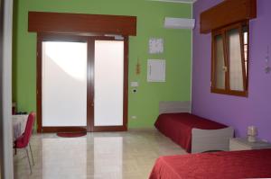 Habitación con 1 dormitorio de color verde y púrpura. en Rooms131, en Margherita di Savoia