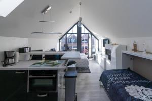 a kitchen with a desk and a bed in a room at Steife Brise in Büsum