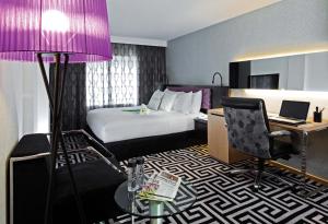 een hotelkamer met een bed en een paarse lamp bij Kew Green Hotel Wanchai Hong Kong in Hong Kong