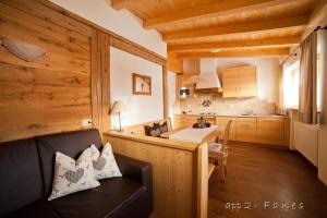un salon avec un canapé et une cuisine dans l'établissement Alp Residence Pelegrin, à San Vigilio Di Marebbe