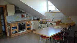 a kitchen with a table and a sink and a table and chairs at Ferienwohnung Familie Hubert Pilsl in Sonnen