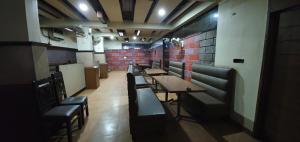 a row of tables and chairs in a restaurant at HOTEL MANUHAR INN in Bārmer