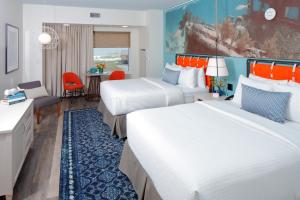 格尔夫海岸Hotel Indigo Orange Beach - Gulf Shores by IHG的有两张床和一张书桌的酒店房间