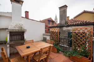 un patio con tavolo e sedie in legno sul balcone. di Rooftop San Marco - Tower View a Venezia