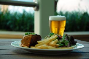 a plate of food and a glass of beer at Captain Cook Hotel Botany in Sydney