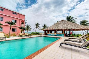 una piscina frente a un edificio rosa en Hibiscus @ Caribe Island, en San Pedro