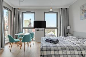 1 dormitorio con 1 cama, mesa y sillas en Blue Mandarin Garden Gates, en Gdansk