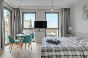 a bedroom with a bed and a table and chairs at Blue Mandarin Garden Gates in Gdańsk