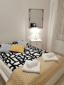een slaapkamer met een bed met twee handdoeken erop bij Cicha Przystań - Apartamenty Wyspa Solna in Kołobrzeg