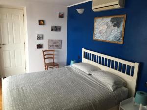 ein Schlafzimmer mit einer blauen Wand und einem Bett in der Unterkunft Sunny Rome Attico con grande terrazzo in Rom