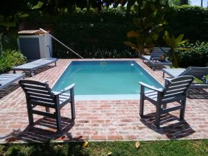 a swimming pool with two chairs and a pair at Casa Chacabuco Tandil in Tandil