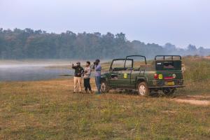 a group of people standing next to a green truck at Pench Jungle Camp in Khawāsa
