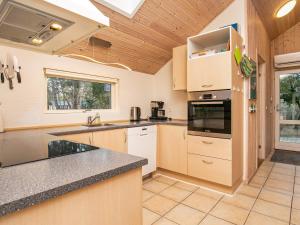 a kitchen with wooden cabinets and a counter top at 12 person holiday home in R dby in Kramnitse