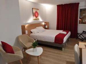 a hotel room with a bed and two chairs at Best Western Hotel & Spa Austria-La Terrasse in Saint-Étienne