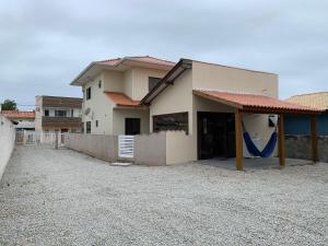 una casa con una hamaca azul fuera de ella en Praia dos Ingleses / Kitnet - 2 km da praia, en Florianópolis