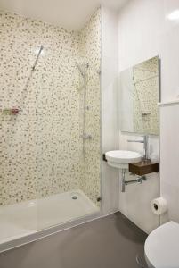 a bathroom with a shower and a toilet and a sink at Caçarola Dois - Alojamento local in Figueira da Foz