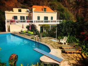 a house with a swimming pool in front of a house at Casa Santa Barbara Deluxe in Ribeira Grande