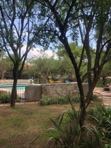 a swimming pool in a yard with a stone wall at Cabañas Apart Margaridas in Merlo