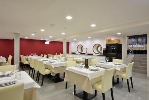 a dining room with white tables and yellow chairs at Caçarola Dois - Alojamento local in Figueira da Foz +26 photos
